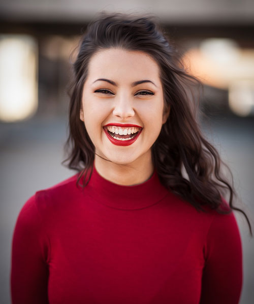 Frau mit rotem Lippenstift und weißen Zähnen lachend