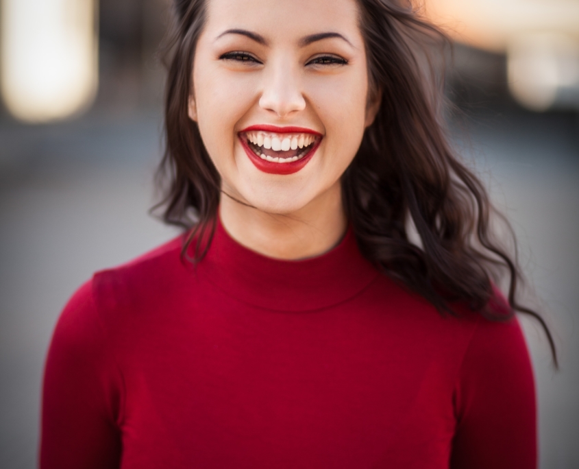 Frau mit rotem Lippenstift und weißen Zähnen lachend